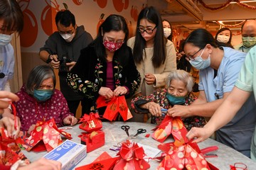 The Secretary for Labour and Welfare, Mr Chris Sun, today (February 7) visited the Kwu Tung North Multi-welfare Services Complex. The Complex adopted the Modular Integrated Construction method and provides residential and community care services for elderly people and persons with disabilities. All seven residential care homes for the elderly (RCHEs) commenced service from August 2023. The Permanent Secretary for Labour and Welfare, Ms Alice Lau, also joined the visit. Photo shows Ms Lau (front row, second left) and residents making festive decorations by red packet envelopes during her visit to one of the RCHEs.