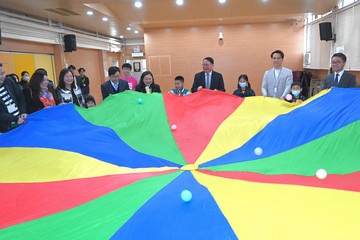 政務司司長陳國基今日（三月十四日）主持第五屆扶貧委員會第五次會議，並率領委員探訪參與在校課後託管服務計劃的學校，實地視察計劃運作。勞工及福利局局長孫玉菡、民政及青年事務局副局長梁宏正和教育局副局長施俊輝亦有隨行。圖示陳國基（右六）、孫玉菡（右九）、施俊輝（右二）和委員與學童進行小組遊戲。