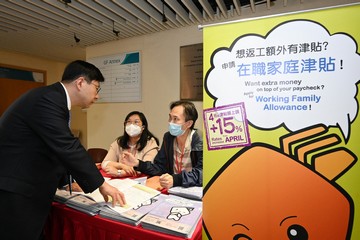 The Secretary for Labour and Welfare, Mr Chris Sun, yesterday (March 28) officiated at the Kick-off Ceremony of District Services and Community Care Teams - Pilot Scheme on Supporting Elderly and Carers and appealed to Care Teams to introduce the Working Family Allowance Scheme to members of the public. Photo shows Mr Sun (left) taking a look at the booth of the Working Family Allowance Office.