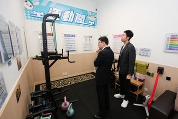 The Secretary for Labour and Welfare, Mr Chris Sun, visited the mobile voter registration booth at the Sham Shui Po Community Living Room today (May 28). Photo shows Mr Sun (left) listening to an introduction by a staff member on the facilities booking mechanism at the gym corner.