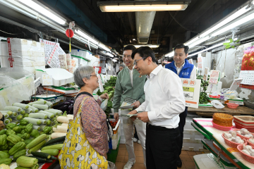 政府长者及合资格残疾人士公共交通票价优惠计划（二元优惠计划）今日（四月三日）起由二元划一收费调整为「两蚊两折」。劳工及福利局局长孙玉菡今日到黄大仙及调景岭视察「两蚊两折」首日实施情况。图示孙玉菡（前排右）在黄大仙大成街街市与市民交流，提示受惠人士二元优惠计划收费调整今日生效。