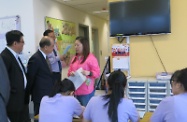 Mr Cheung (second left) is accompanied by the Assistant Director of Social Welfare (Youth and Corrections), Mr Peter Ng (first left), while receiving a briefing on the activities provided to residents of the Home.