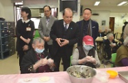 Mr Cheung (centre) observes elderly residents making dumplings at Ho Yam Care and Attention Home for the Elderly.
