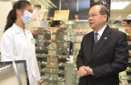 Mr Cheung (right) visits the optometry centre located at Sik Sik Yuen Social Services Complex and talks to a staff member to learn about the centre's daily operation.