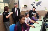 The Secretary for Labour and Welfare, Dr Law Chi-kwong (second left), visits the Hong Kong Society for the Aged Chai Wan District Elderly Community Centre and is briefed by a representative of the centre on its services.