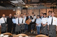 The Secretary for Labour and Welfare, Dr Law Chi-kwong, visited a restaurant in Quarry Bay under the social enterprise Gingko House. Photo shows Dr Law (front row, fourth right) and the Under Secretary for Labour and Welfare, Mr Caspar Tsui (back row, second left), with staff of the restaurant.