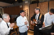 The Secretary for Labour and Welfare, Dr Law Chi-kwong (second right), visits a restaurant in Quarry Bay under the social enterprise Gingko House and plays a tune together with the elderly band members of the restaurant.