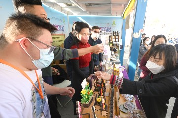 The Secretary for Labour and Welfare, Mr Chris Sun, accompanied by the Director of Social Welfare, Miss Charmaine Lee; the Commissioner for Rehabilitation, Miss Vega Wong; and the Chairperson of the Advisory Committee on Enhancing Employment of People with Disabilities, Dr Kevin Lau, visited the 56th Hong Kong Brands and Products Expo at Victoria Park today (December 22). Photo shows Miss Lee (first right) shopping at a booth set up by a rehabilitation service unit.