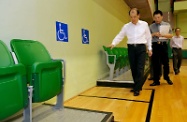 Mr Cheung (left) inspects the wheelchair spaces provided at a spectator stand inside Hung Hom Municipal Services Building Sports Centre.