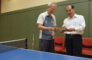 Mr Cheung (right) introduces to an elderly citizen the Government's new policy to make it easier to get around.
