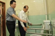 Mr Cheung (right) inspects the accessible toilet and changing room at the Sports Centre.