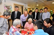 The Secretary for Labour and Welfare, Dr Law Chi-kwong, visited Islands District and toured the Neighbourhood Advice-Action Council (NAAC) Tung Chung Integrated Services Centre. Photo shows (from back row, sixth right) Dr Law; the Executive Director of the NAAC, Mr Tai Keen-man; the District Social Welfare Officer (Central Western, Southern and Islands), Ms Ip Siu-ming; the Under Secretary for Labour and Welfare, Mr Caspar Tsui; the District Officer (Islands), Mr Anthony Li; and the Chairman of the NAAC, Mr Tony Yen, watching elderly persons playing a board game.