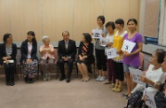 Mr Cheung (fourth left), accompanied by the District Social Welfare Officer (Kowloon City/Yau Tsim Mong) of the SWD, Ms Wong Yin-yee (fifth left), and Ms Tam (second left), listens as a voluntary tutor (third left) talks about her experiences in teaching English classes for new arrivals and retirees in the past 10 years.