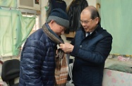 劳工及福利局局长张建宗（右）今日（一月二十五日）探访土瓜湾一名独居长者，并为其送上御寒衣物，表达关怀。