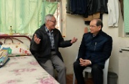 Mr Cheung (right) chats with the elderly person to understand his needs and reminds him to keep warm during the cold spell.