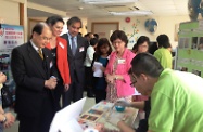 Mr Cheung (first left), Dr Aron Harilela (third left) and Mrs Harilela (second left), observe a trainee creating a mosaic art piece.