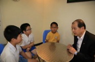 Mr Cheung chats with some youth members at the Hong Kong Children and Youth Services Jockey Club Belvedere Garden Integrated Children and Youth Services Centre.