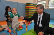 The Secretary for Labour and Welfare, Dr Law Chi-kwong, today (November 26) visited the Community Carer's Cafe in the Sheung Shui Integrated Family Service Centre co-organised by the Social Welfare Department and the Hong Kong Federation of Women's Centres to take a closer look at support services for carers. Photo shows Dr Law (right) visiting a child being looked after temporarily by a volunteer at the Cafe.