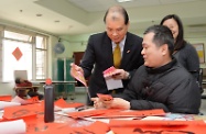 Mr Cheung (centre) exchanges Lunar New Year well wishes with a resident who is a Chinese calligraphy lover.