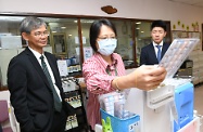 The Secretary for Labour and Welfare, Dr Law Chi-kwong, called at Chi Lin Care and Attention Home and Chi Lin Day Care Centre for the Elderly and visited elderly persons. Photo shows Dr Law (left) watching staff demonstrating the use of the automated drug-dispensing system.
