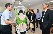 The Secretary for Labour and Welfare, Dr Law Chi-kwong, called at Tuen Mun Long Stay Care Home of the New Life Psychiatric Rehabilitation Association and visited residents with chronic mental illness. Photo shows Dr Law (first right) and the Under Secretary for Labour and Welfare, Mr Caspar Tsui (centre), being briefed on a ceiling hoist system, which assists residents to receive physiotherapy.