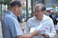 Mr Cheung (right) distributes leaflets to the public.