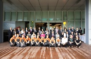 Mr Cheung (centre, middle row), the Permanent Secretary for Labour and Welfare, Miss Annie Tam (sixth left, middle row), the Director of Social Welfare, Ms Carol Yip (fifth right, middle row), and other officials of the Labour and Welfare Bureau and Social Welfare Department are pictured with the Chairman, Dr Ina Chan (seventh left, middle row), directors and other representatives of Tung Wah Group of Hospitals.  People in front row wearing orange uniform are staff of the i-bakery.