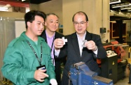 张建宗（右）参观港铁公司的机械工场，观察学徒的日常训练环境。